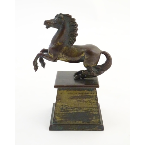 1124 - An early 20thC cast model of a rearing horse, on a tapered plinth base. Approx. 5 3/4