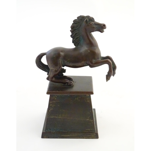 1124 - An early 20thC cast model of a rearing horse, on a tapered plinth base. Approx. 5 3/4