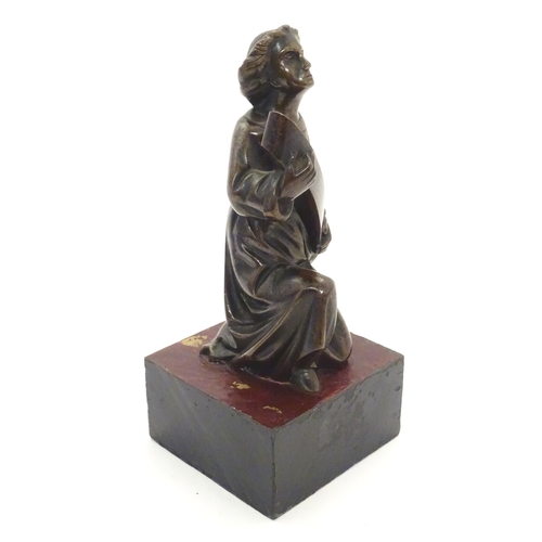 1126 - A 20thC cast bronze model of a classical figure kneeling with a large scroll. Approx. 7