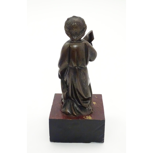 1126 - A 20thC cast bronze model of a classical figure kneeling with a large scroll. Approx. 7