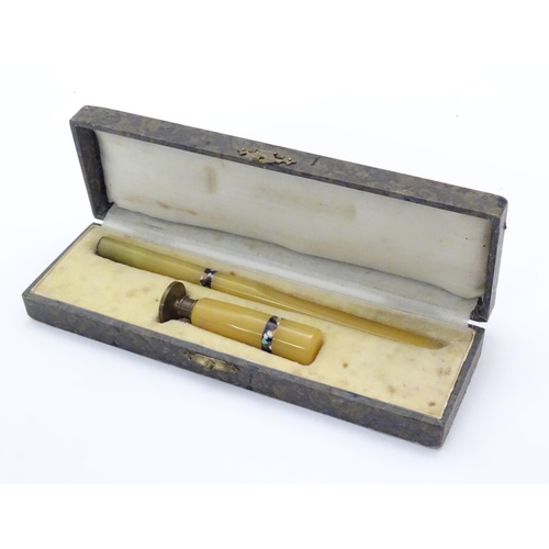 1148 - An Art Deco catalin letter opener and desk / hand seal with banded decoration. Cased. Letter opener ... 