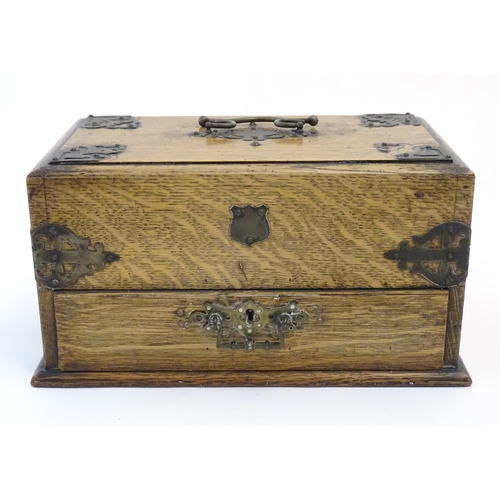 1174 - A Victorian oak smokers companion box with applied mounts and handles, opening to reveal various com... 