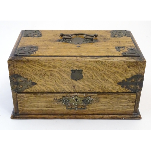 1174 - A Victorian oak smokers companion box with applied mounts and handles, opening to reveal various com... 