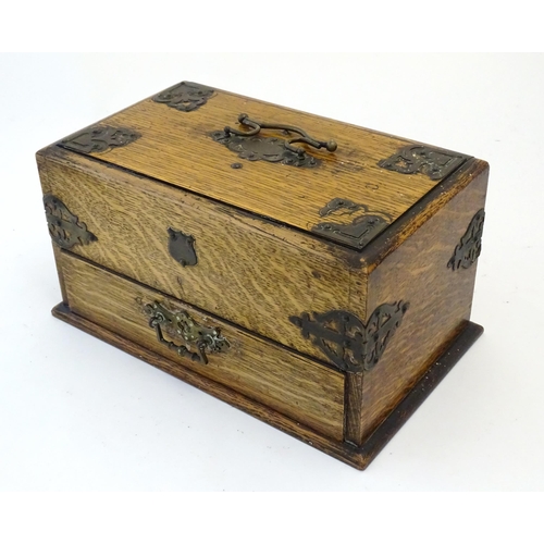 1174 - A Victorian oak smokers companion box with applied mounts and handles, opening to reveal various com... 