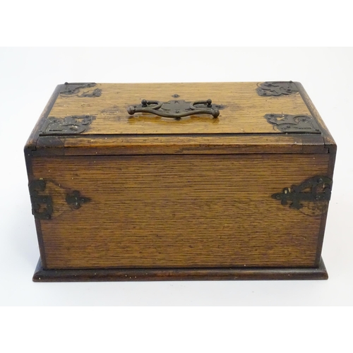 1174 - A Victorian oak smokers companion box with applied mounts and handles, opening to reveal various com... 