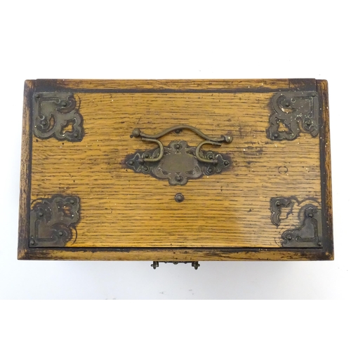 1174 - A Victorian oak smokers companion box with applied mounts and handles, opening to reveal various com... 