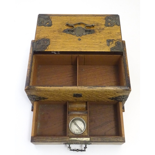 1174 - A Victorian oak smokers companion box with applied mounts and handles, opening to reveal various com... 