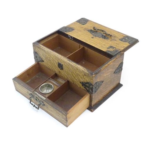 1174 - A Victorian oak smokers companion box with applied mounts and handles, opening to reveal various com... 