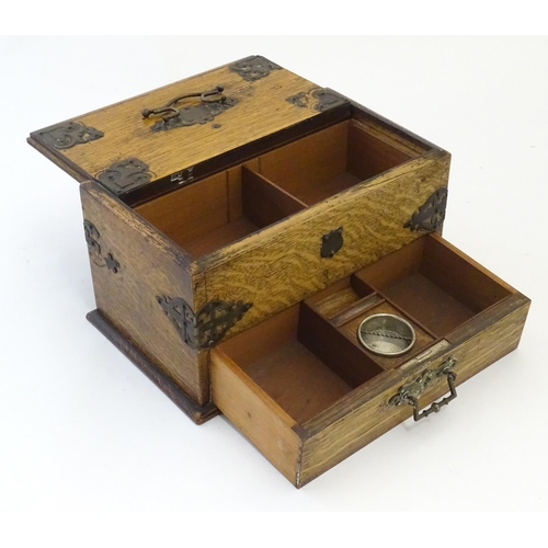 1174 - A Victorian oak smokers companion box with applied mounts and handles, opening to reveal various com... 