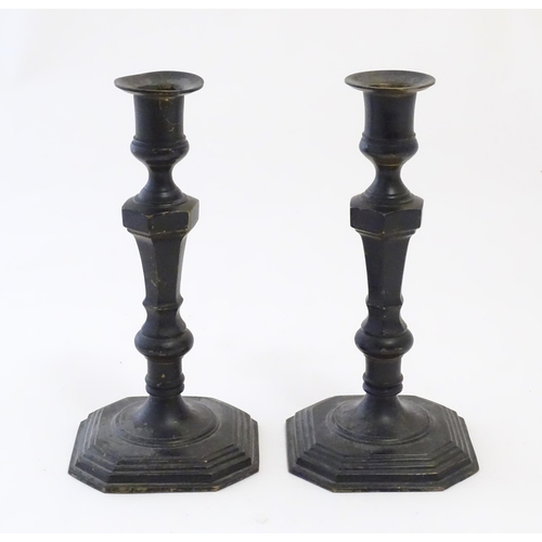 1191 - A pair of 20thC cast candlesticks with double knop faceted stems on a stepped square base with cante... 