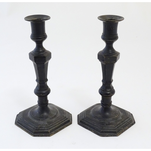 1191 - A pair of 20thC cast candlesticks with double knop faceted stems on a stepped square base with cante... 