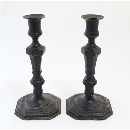 1191 - A pair of 20thC cast candlesticks with double knop faceted stems on a stepped square base with cante... 