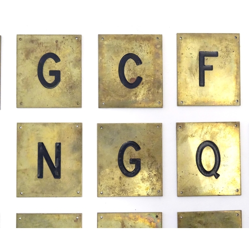 1215 - A quantity of 20thC brass plaques each with an enamel letter, comprising A, O, H, G, C, F, Q, E, L, ... 