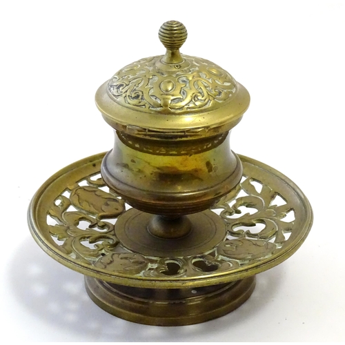 1216 - A Victorian cast brass desk inkwell of pedestal form with pierced foliate base. Approx. 4 3/4