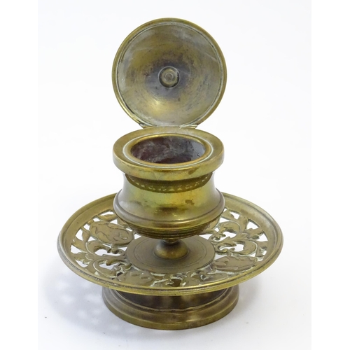 1216 - A Victorian cast brass desk inkwell of pedestal form with pierced foliate base. Approx. 4 3/4