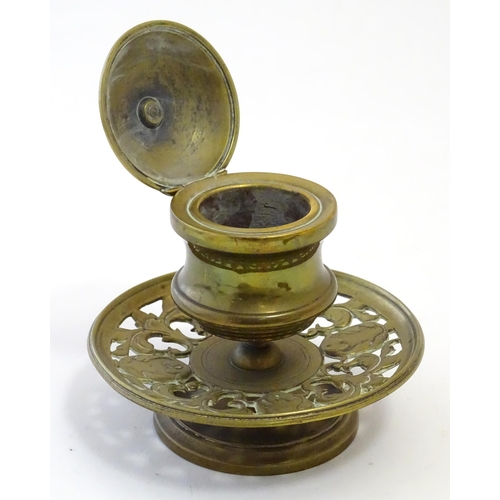 1216 - A Victorian cast brass desk inkwell of pedestal form with pierced foliate base. Approx. 4 3/4