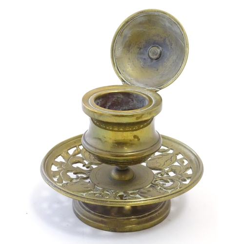 1216 - A Victorian cast brass desk inkwell of pedestal form with pierced foliate base. Approx. 4 3/4