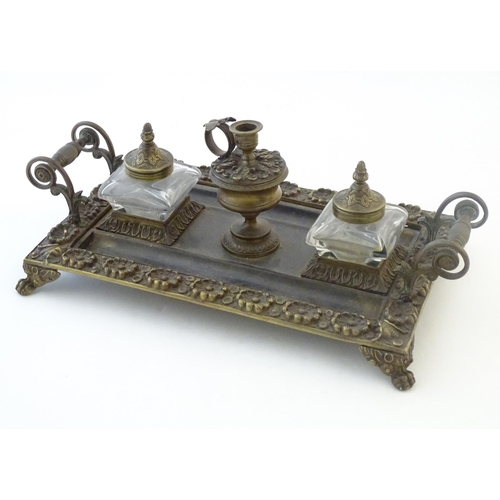 1253 - A Victorian cast brass standish / inkwell of rectangular form with twin scrolling handles and floral... 