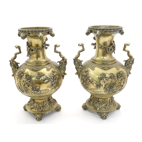 1278 - A pair of Oriental brass vases with twin handles formed as stylised beasts, the body decorated with ... 