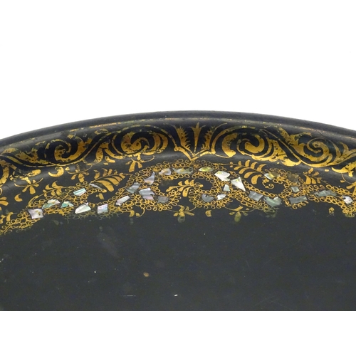 1286 - A 19thC papier mache lacquered tray of oval form with gilt foliate decoration and inlaid abalone det... 