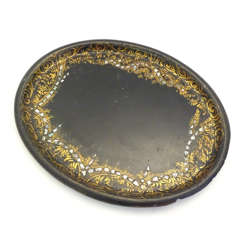 1286 - A 19thC papier mache lacquered tray of oval form with gilt foliate decoration and inlaid abalone det... 