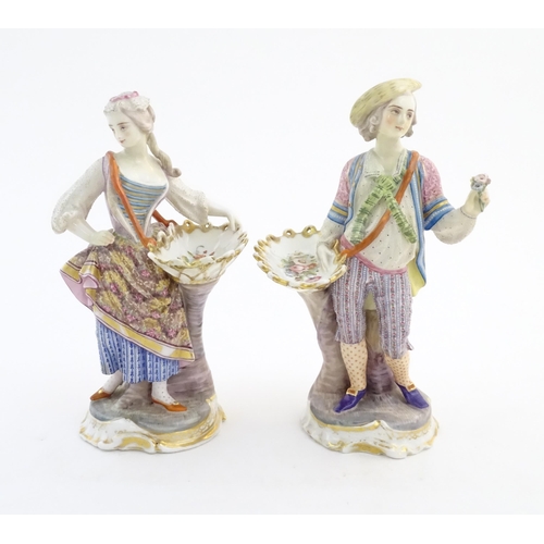 100 - A pair of Continental porcelain figures modelled as a lady and gentleman with flower baskets. Togeth... 