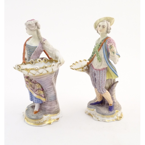 100 - A pair of Continental porcelain figures modelled as a lady and gentleman with flower baskets. Togeth... 