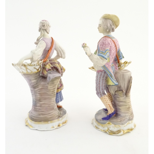 100 - A pair of Continental porcelain figures modelled as a lady and gentleman with flower baskets. Togeth... 