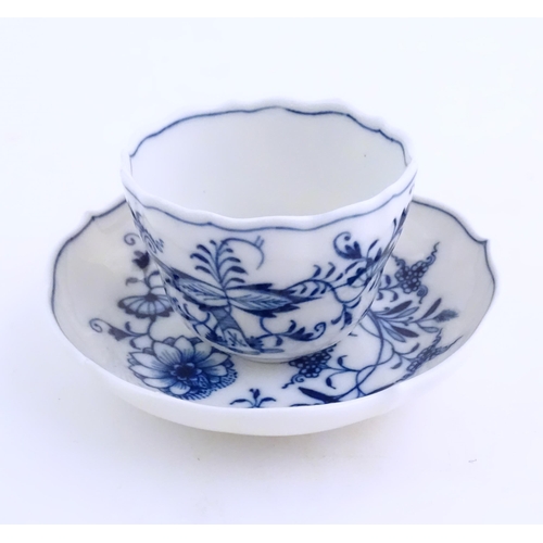 101 - A Meissen blue and white cup and saucer in the onion pattern. With blue crossed sword mark under. Cu... 