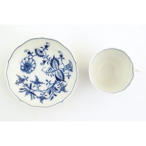 101 - A Meissen blue and white cup and saucer in the onion pattern. With blue crossed sword mark under. Cu... 