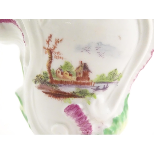 102 - A Rococo style vase of asymmetric form decorated with hand painted landscape scenes in the Derby sty... 