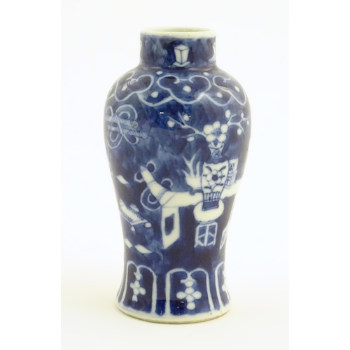 13 - A small Chinese blue and white vase decorated with flowers in a vase and banded borders. Character m... 