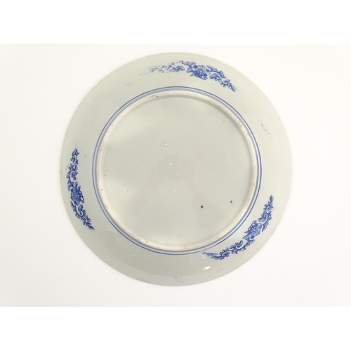14 - An Oriental blue and white charger with transfer decoration depicting a landscape scene with flowers... 