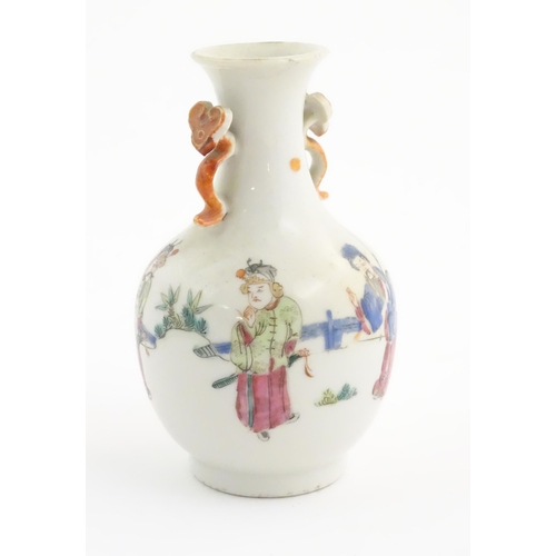 28 - A small Chinese famille rose vase with twin handles of ruyi sceptre form, the body decorated with fi... 