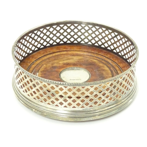 435 - A silver bottle coaster with turned wooden base hallmarked Birmingham 2000, maker W. I. Broadway & C... 