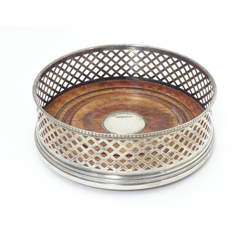 435 - A silver bottle coaster with turned wooden base hallmarked Birmingham 2000, maker W. I. Broadway & C... 