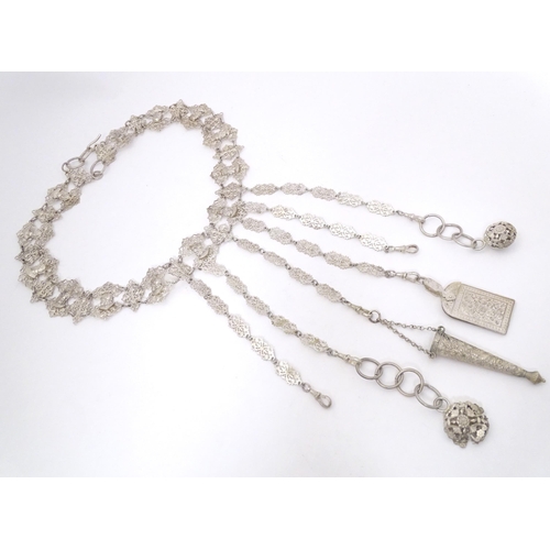 441 - A Dutch silver and white metal chatelaine belt with six hanging chains with scissor keep, aide de me... 