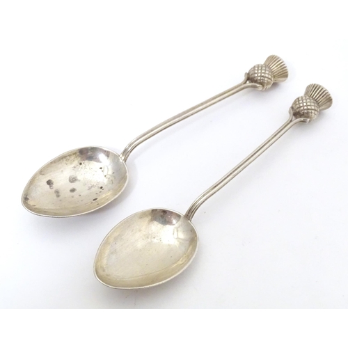 468 - A pair of Scottish silver teaspoons the handles surmounted by thistle detail, hallmarked Glasgow 195... 