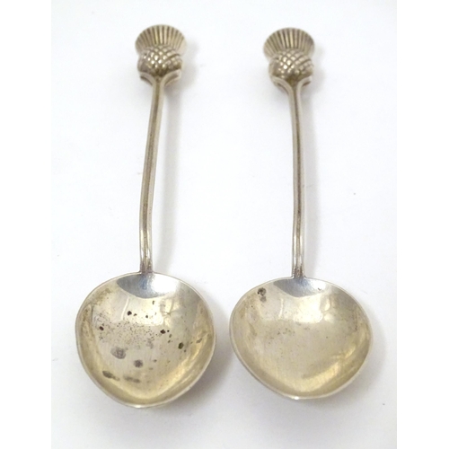 468 - A pair of Scottish silver teaspoons the handles surmounted by thistle detail, hallmarked Glasgow 195... 