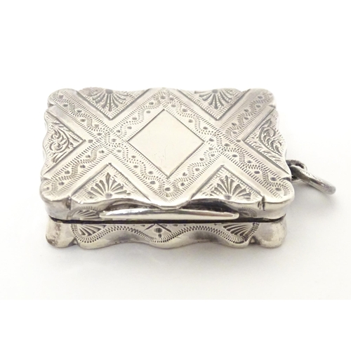 511 - A Victorian silver vinaigrette with engraved decoration opening to reveal grille within, hallmarked ... 