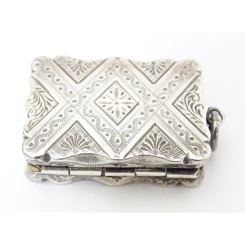 511 - A Victorian silver vinaigrette with engraved decoration opening to reveal grille within, hallmarked ... 