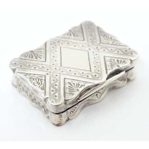 511 - A Victorian silver vinaigrette with engraved decoration opening to reveal grille within, hallmarked ... 