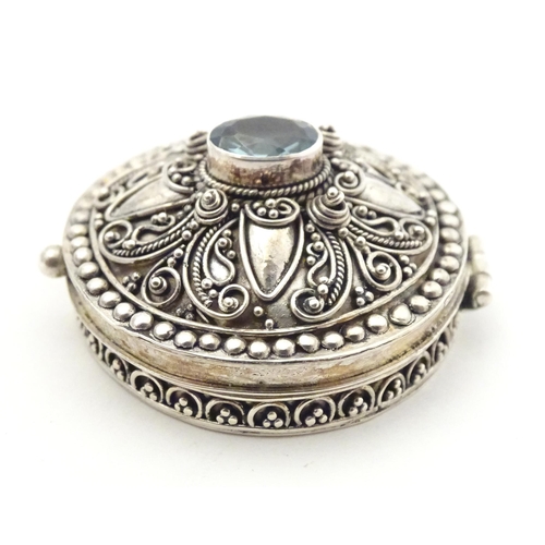 512 - A .925 silver pill box with hinge lid and blue paste stone to top. Approx. 1 1/4