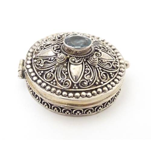 512 - A .925 silver pill box with hinge lid and blue paste stone to top. Approx. 1 1/4