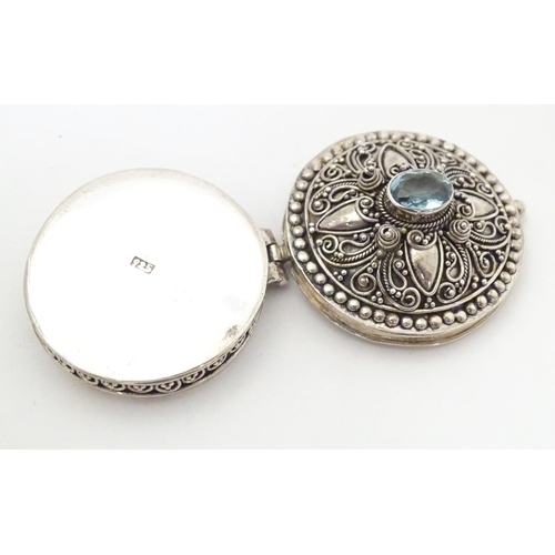 512 - A .925 silver pill box with hinge lid and blue paste stone to top. Approx. 1 1/4