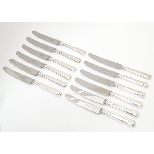 338 - A set of six silver handled knives hallmarked Sheffield 1975, maker Henry Hutton & Co. Together with... 