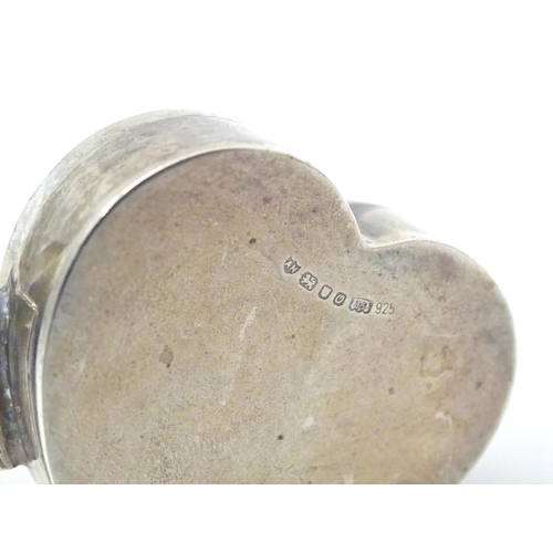 355 - A silver pill box of heart form with embossed decoration and hinged lid. Hallmarked London 1988 make... 