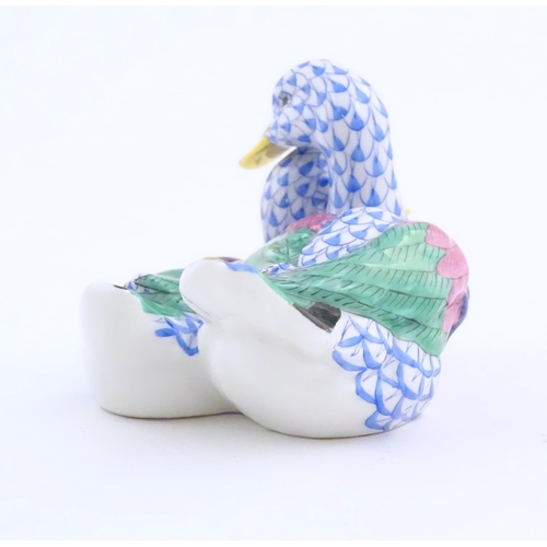 111 - A 20thC Herend pottery model of two ducks with fishnet decoration and gilt highlights. Marked under.... 