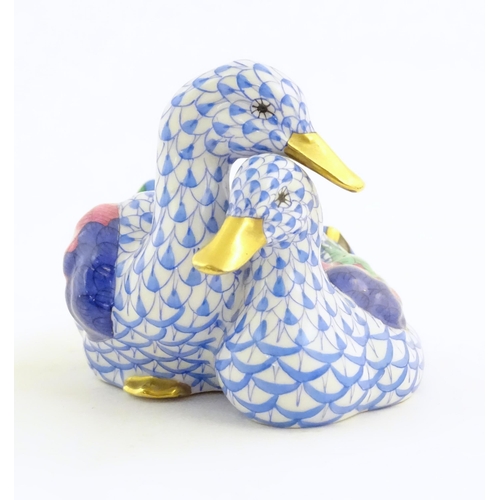 111 - A 20thC Herend pottery model of two ducks with fishnet decoration and gilt highlights. Marked under.... 