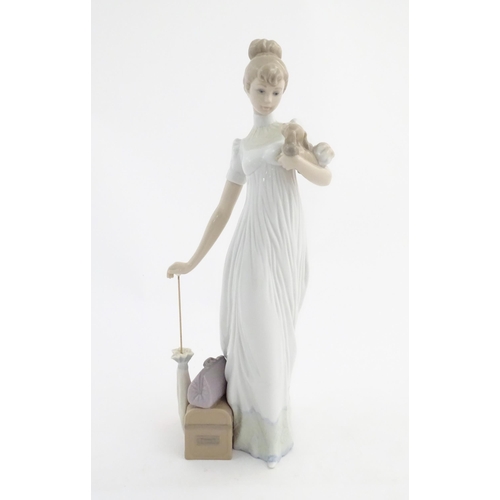 114 - A Lladro figure modelled as a lady with luggage and a small dog, Travelling Companions, model no. 07... 